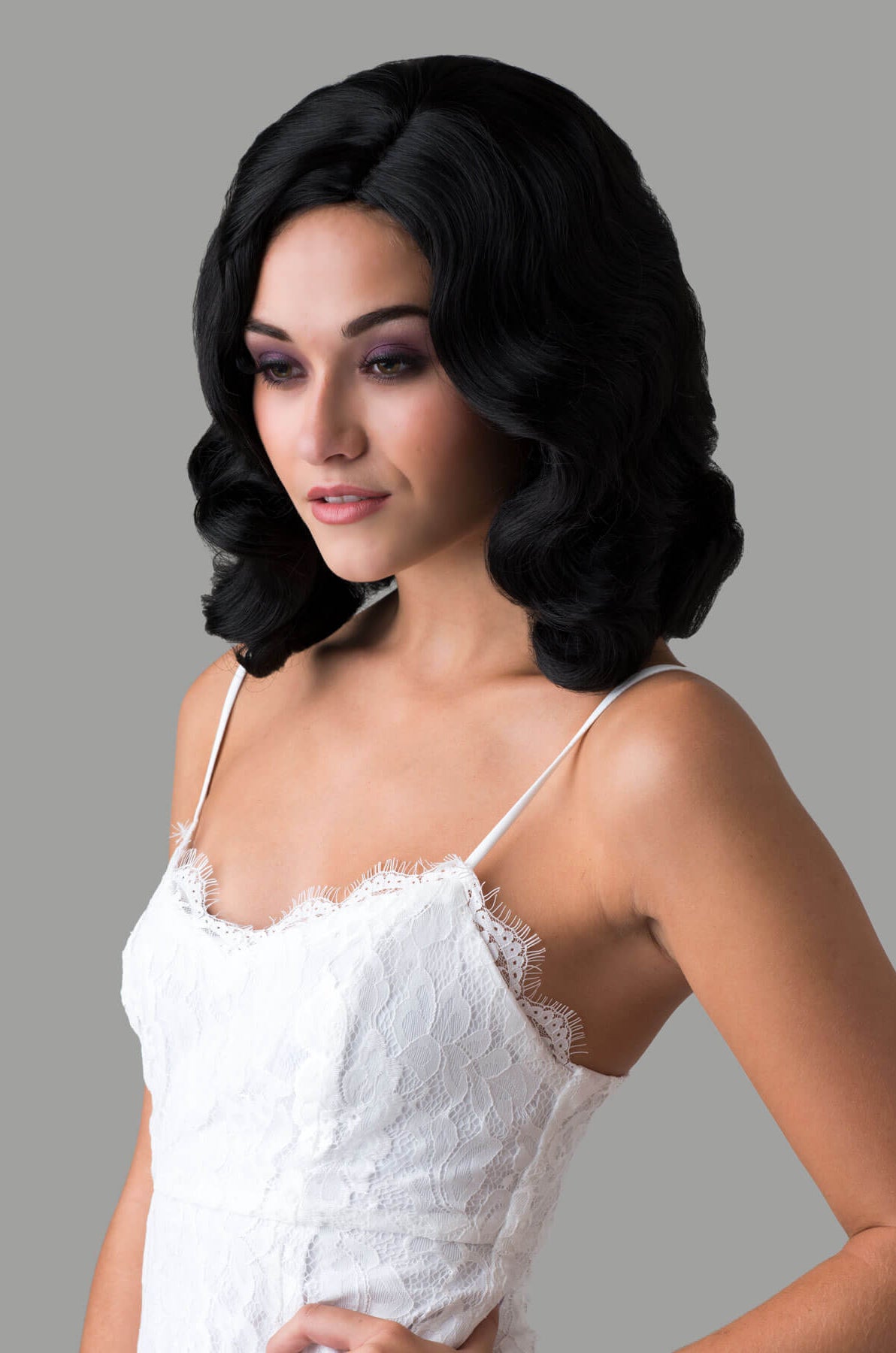 Woman wearing a black wig with a gray background. Black 40s style wig with beautiful marcel waves: Dita