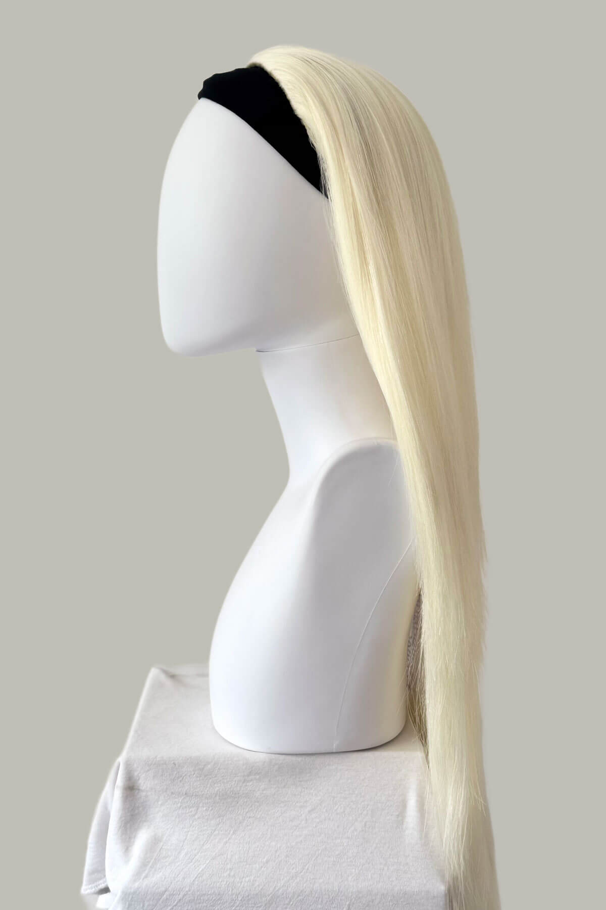 Blonde wig on a mannequin head against a plain background. Straight platinum blonde half wig hairpiece (3/4 wig): Shannon platinum 1001