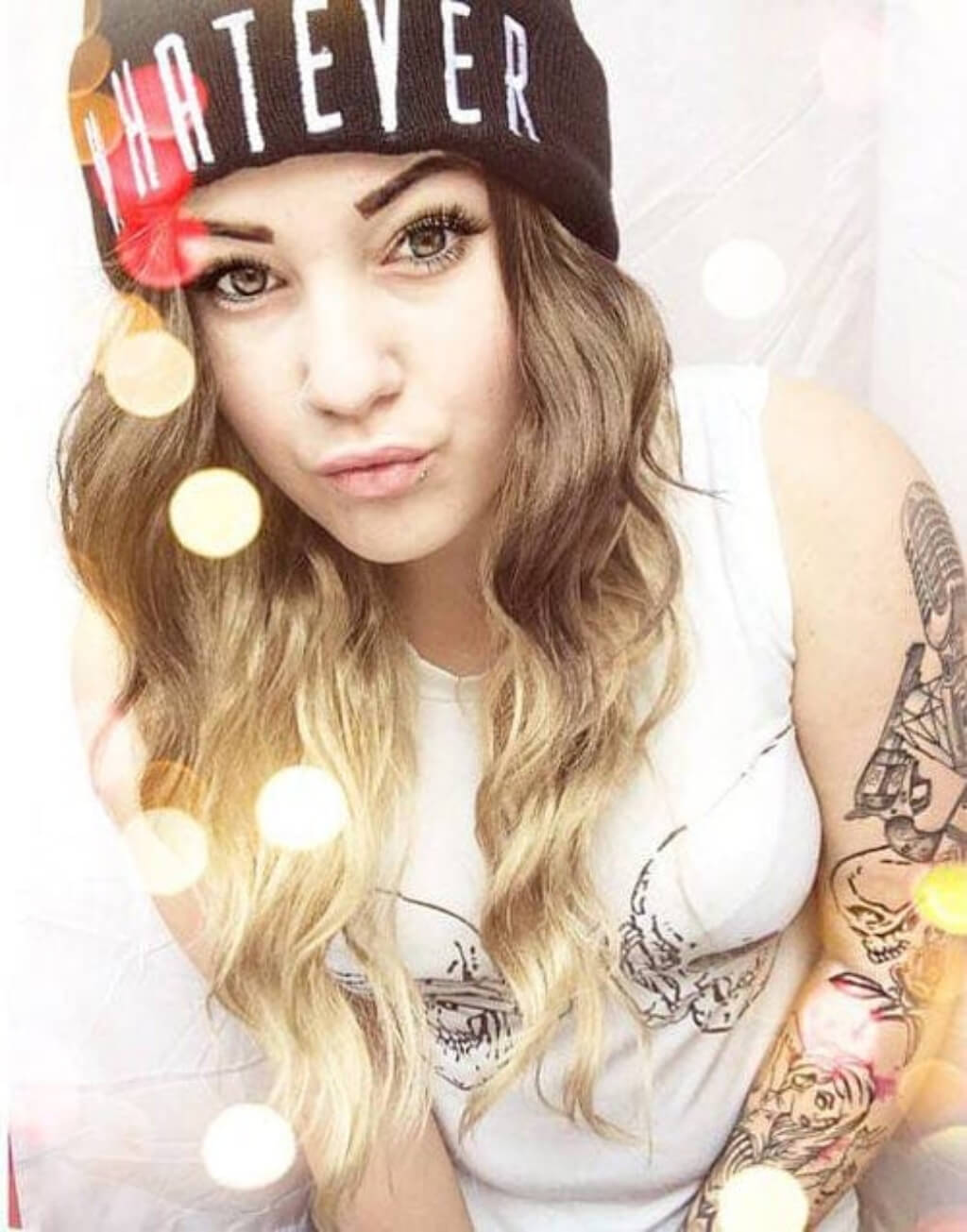 Person wearing a black beanie, holding lights, and showing tattoos. Dip dye chocolate brown and honey blonde wig long wavy wig with no fringe: Genevieve