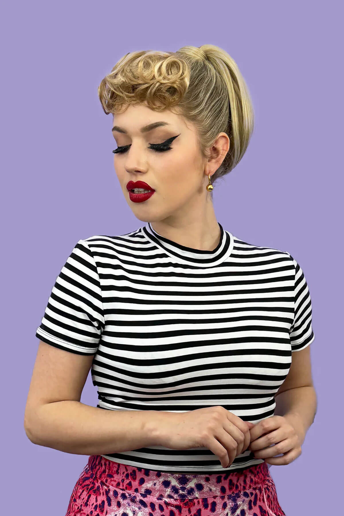 Woman wearing a black and white striped shirt against a purple background. Curly 1940s style clip-in fringe hairpiece/clip-in bangs: Bunny ginger