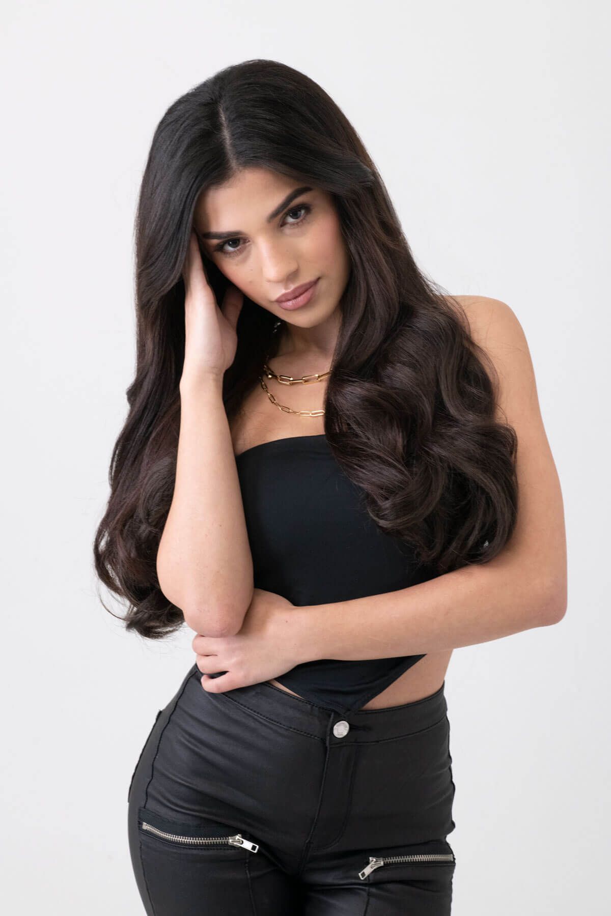 Woman wearing a black top and black pants with zippers on a white background. synthetic hair extension set, 5 piece, 18 inches long, 260g dark brown 4