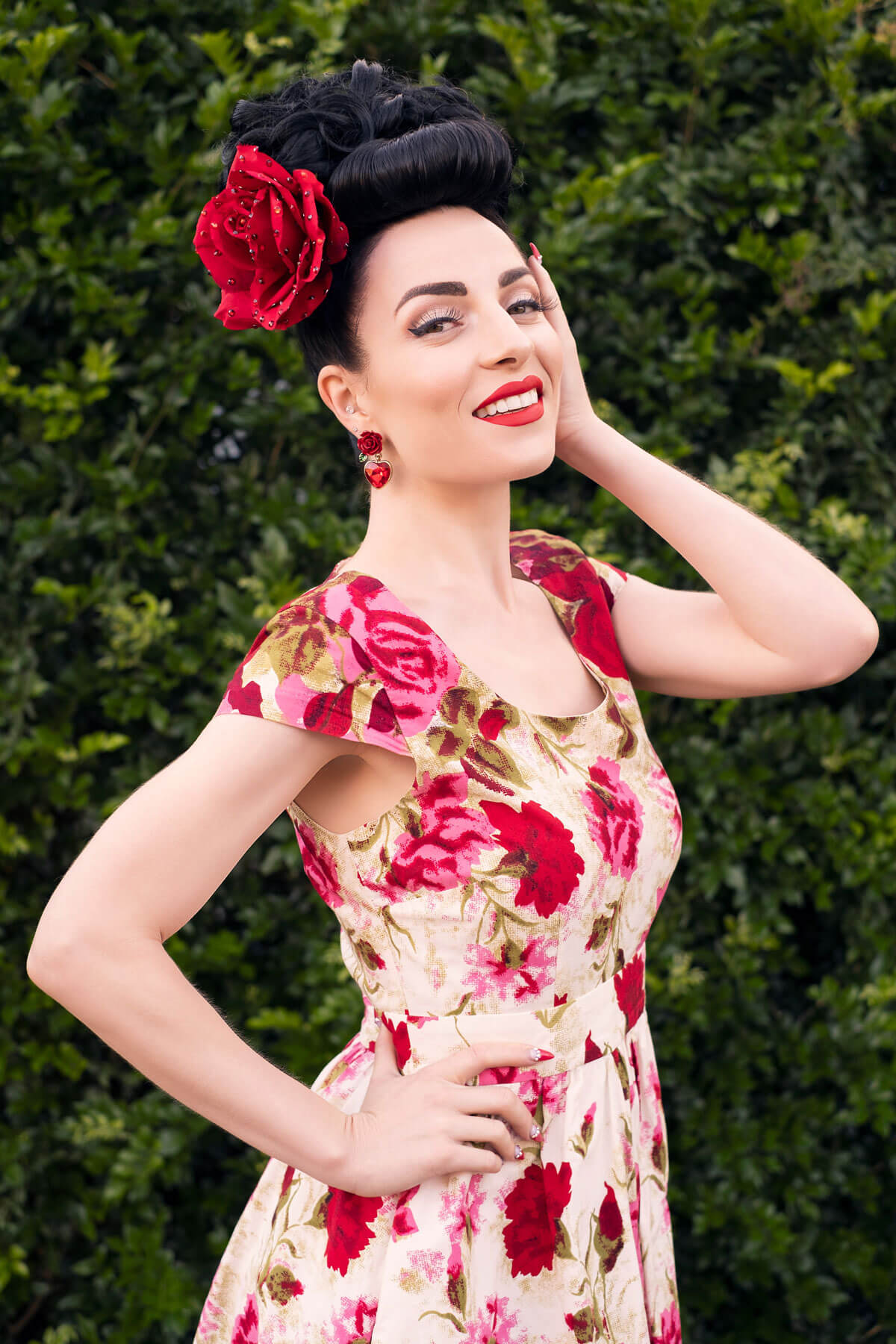 Woman in a floral dress with red flowers against a green background. Bumper bangs pack - vintage 40s 50s fringe roll: Lena dark brown 2