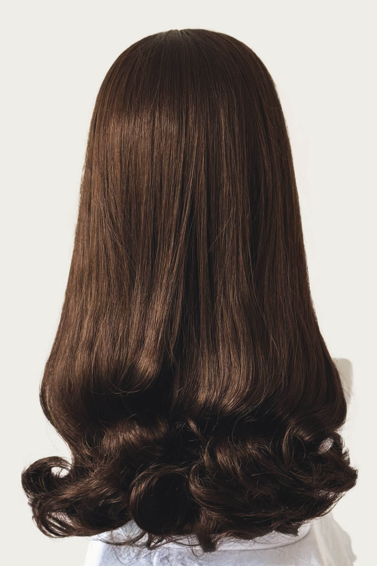 Brown wig on a mannequin head against a white background. 1960s Retro high crown, half wig hairpiece, long with hair flip: Priscilla chestnut brown 8