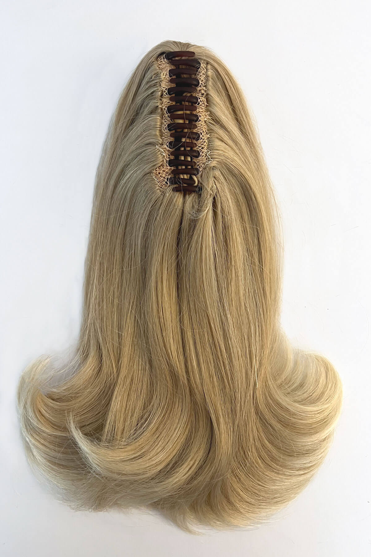 Blonde hair extension with brown clip on a white background. Ponytail hairpiece, shoulder length with flick/flip, retro 1960s style: Ariana blonde 613T24