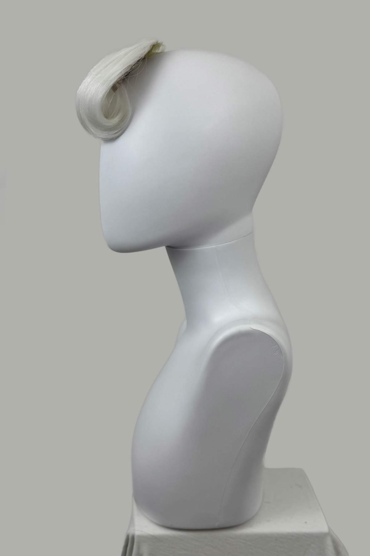 Mannequin head with a white wig on a gray background. Victory roll fringe/bangs hairpiece, 1950s vintage style: Rosa platinum 1001