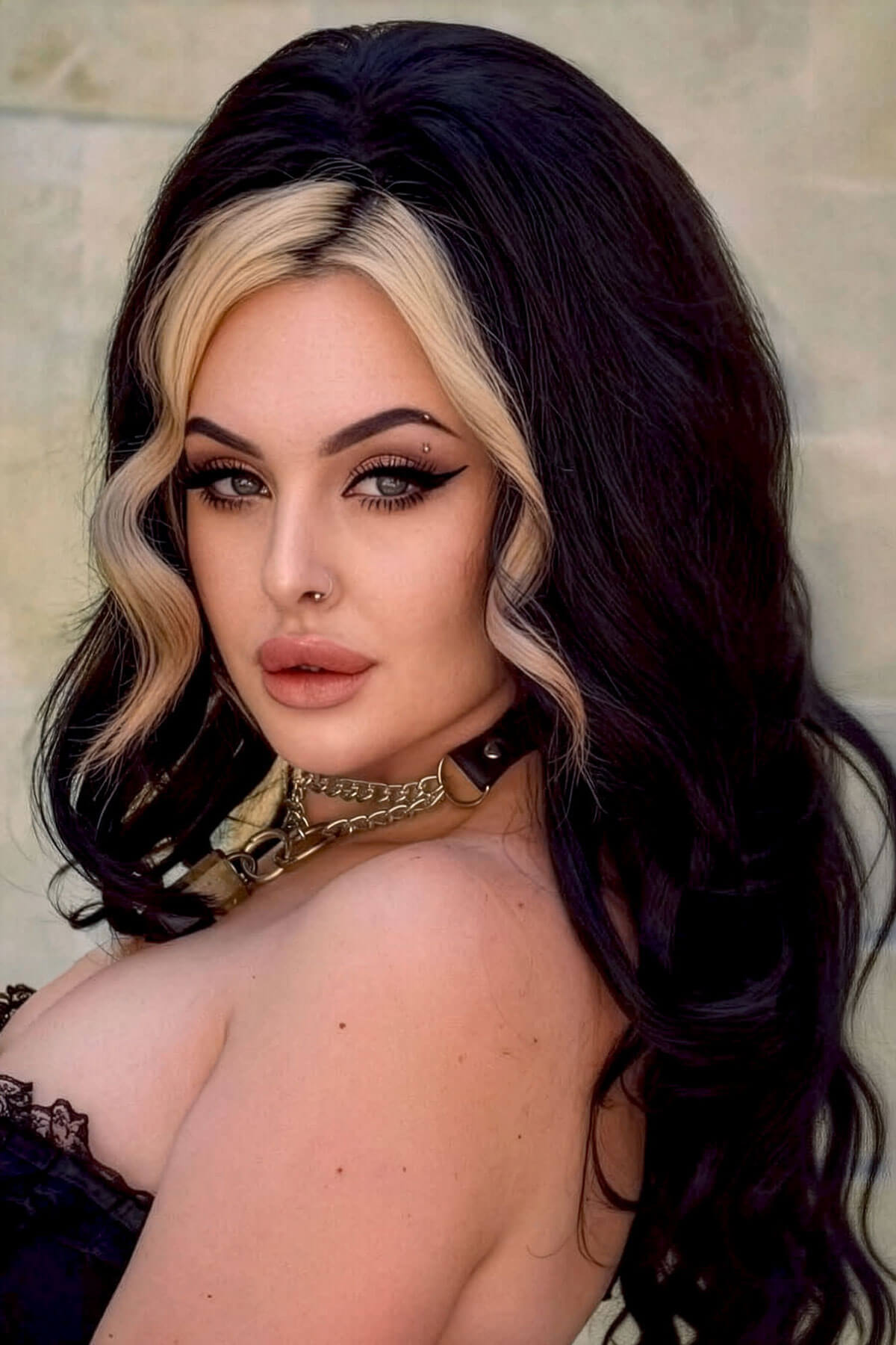 Woman with long, wavy hair posing against a neutral background. High crown long, wavy half wig and volume ring: Bardot jet black 1