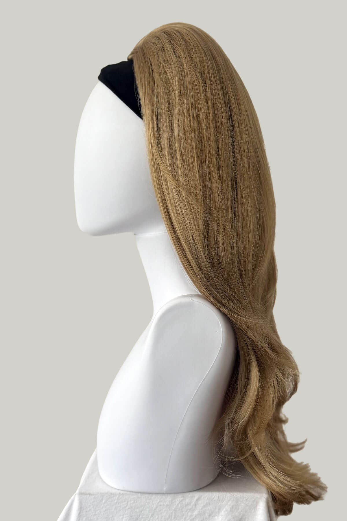 Mannequin head with long blonde wig on a plain background. 1960s style hair, high crown long straight and layered half wig: Juliette 24H613