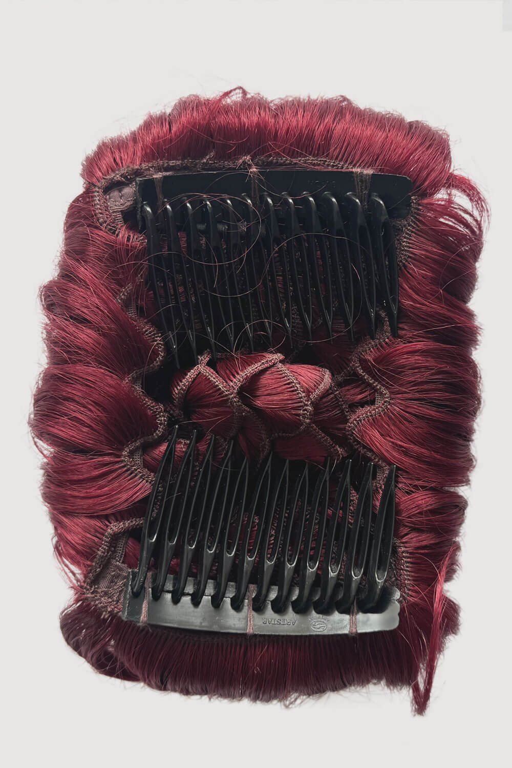 Red hairpiece with black combs on a white background. Hair poodle clip-in hairpiece bun vintage style 1950s: Lucille cherry red 39