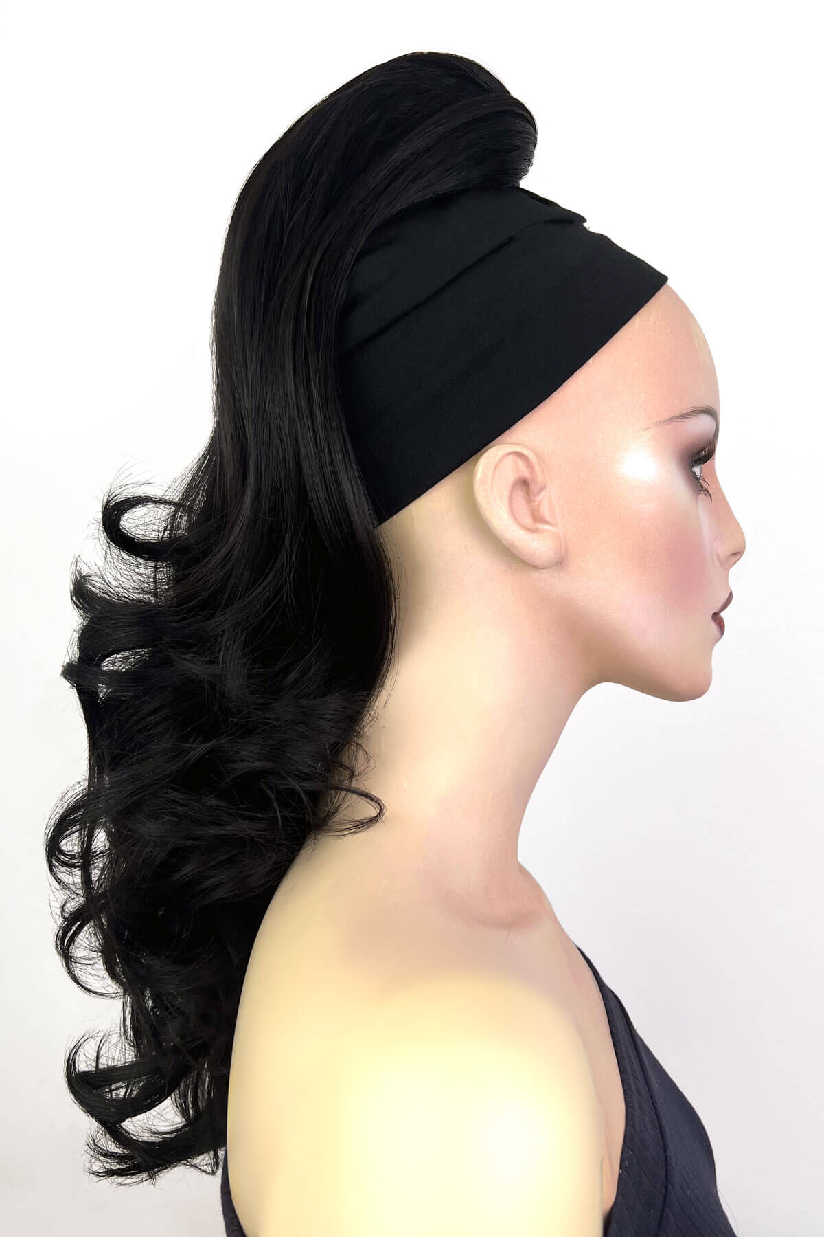 Mannequin head with black hair styled in a ponytail and headband against a white background. Wavy, long ponytail hairpiece extension: Casey black 1b