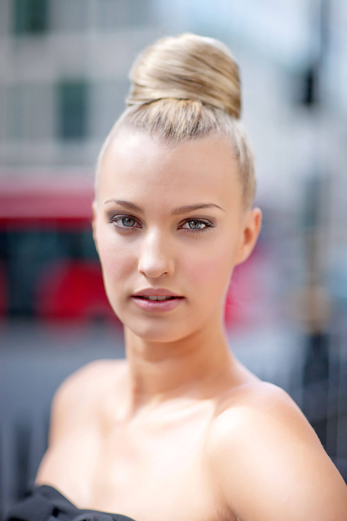 Woman with blonde hair styled in a bun against a blurred background