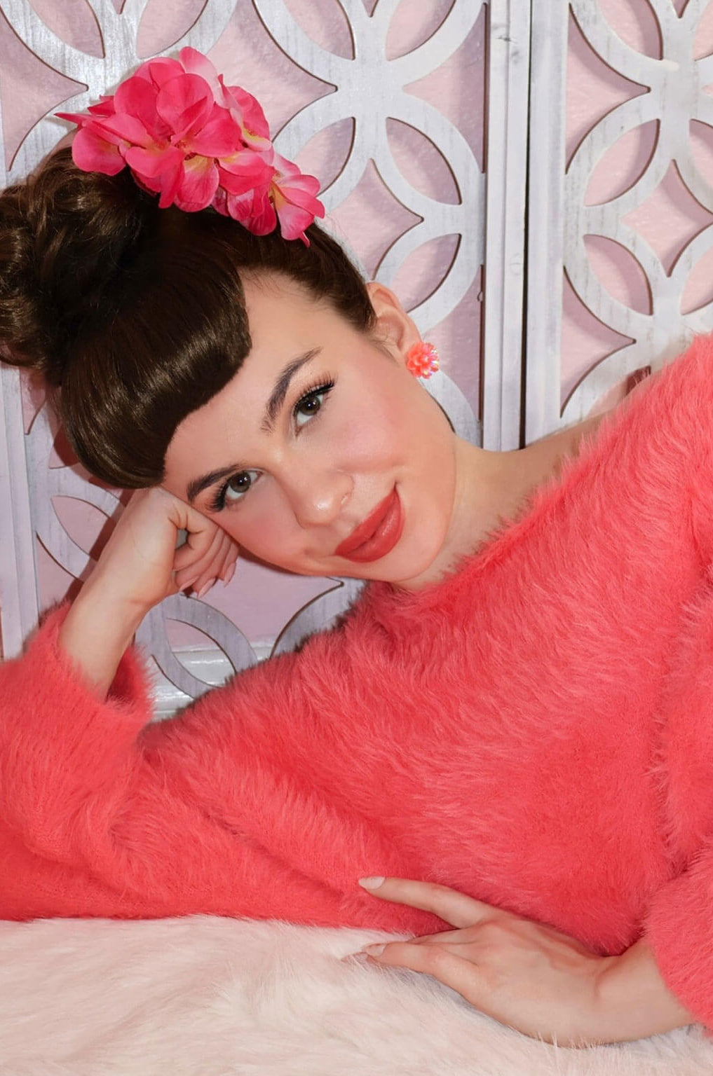 Woman in a pink robe with a decorative headpiece against a white lattice background. Victory roll fringe/bangs, 1950s vintage style: Rosa