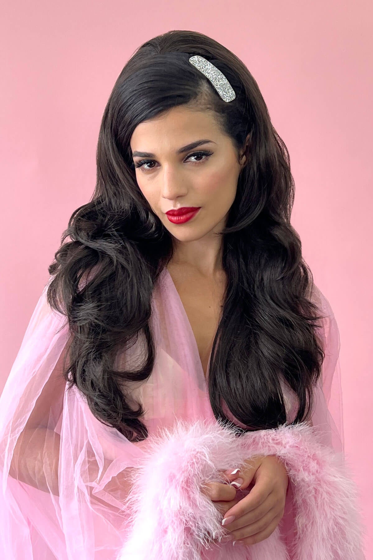 Woman with long wavy hair wearing a headband against a pink background. High crown long, layered half wig and volume ring: Helena jet black #1