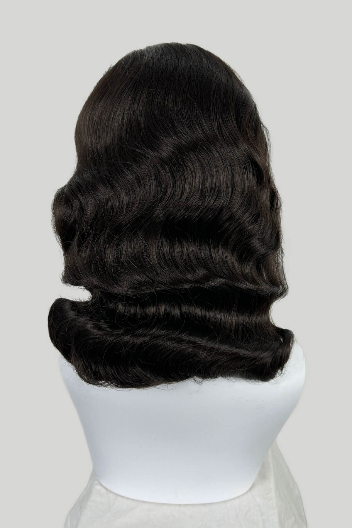 Black wig on a white mannequin head against a light gray background. 1950s style half wig hairpiece with deep finger waves: Deborah Dark brown 4