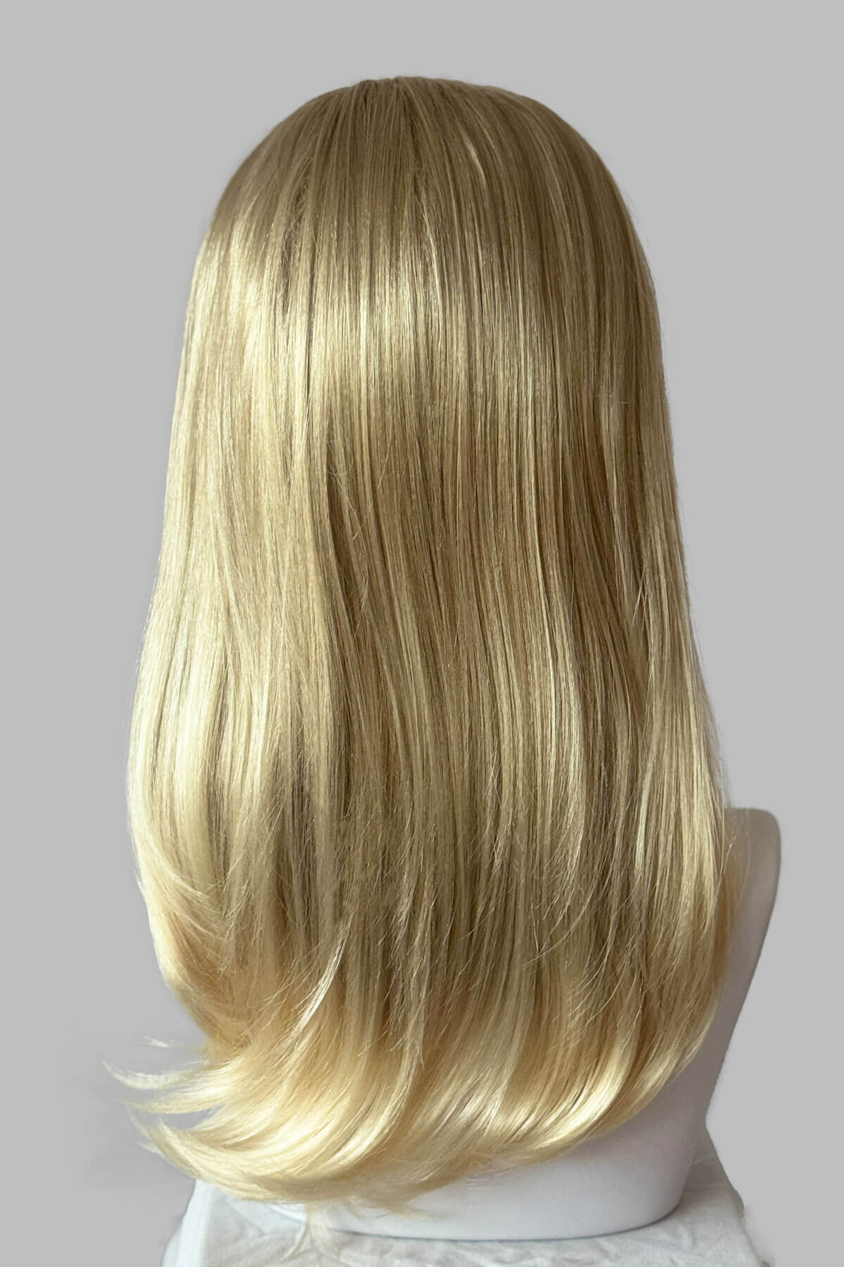 A close-up of a headband blonde half wig hairpiece showing the texture of the hair. Headband half wig hairpiece, long and straight: Isla Blonde 613T24