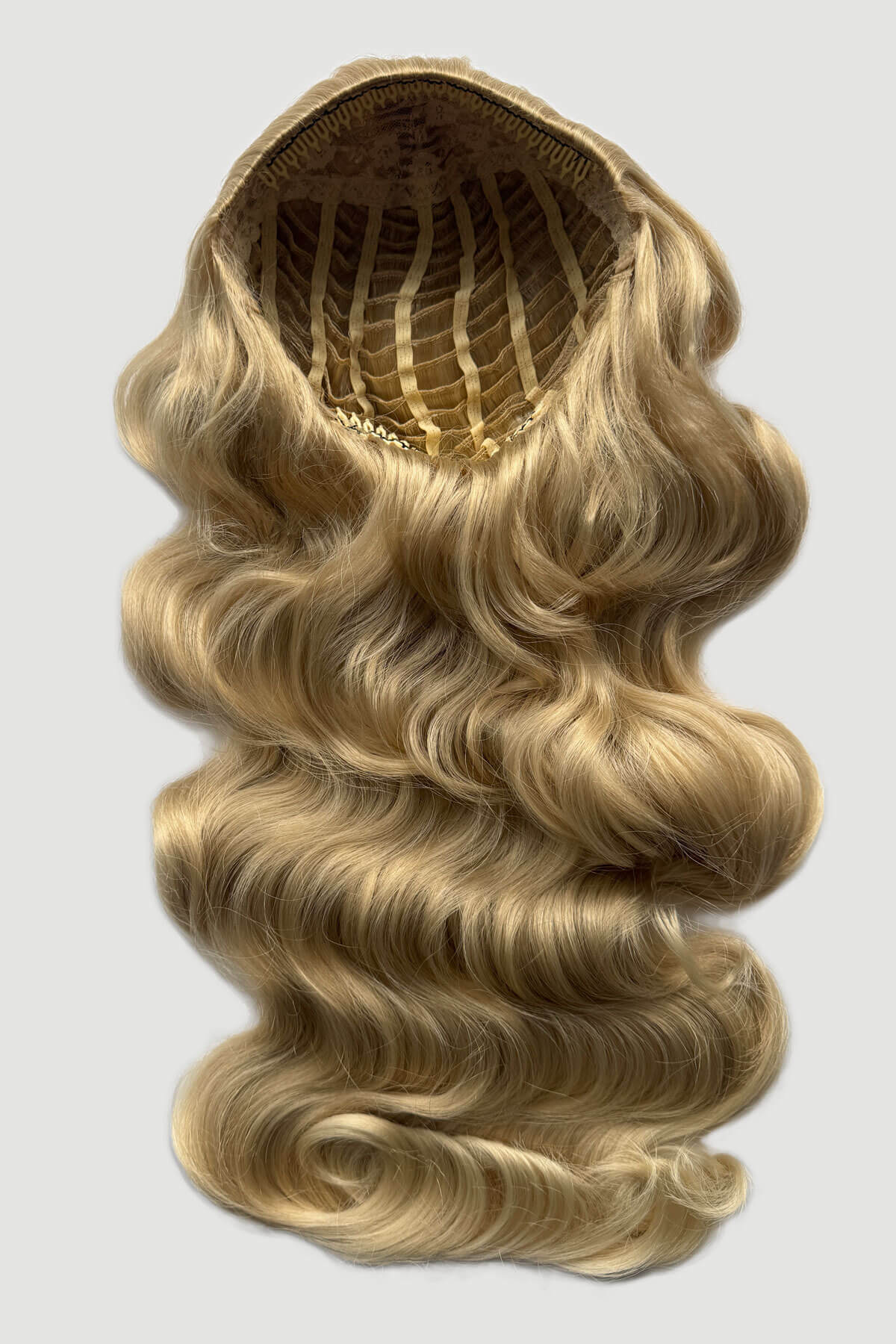 Mannequin head with long, blonde hair styled in a ponytail on a plain background. Ultra long half wig with hollywood waves. ash blonde and light blonde 613T24