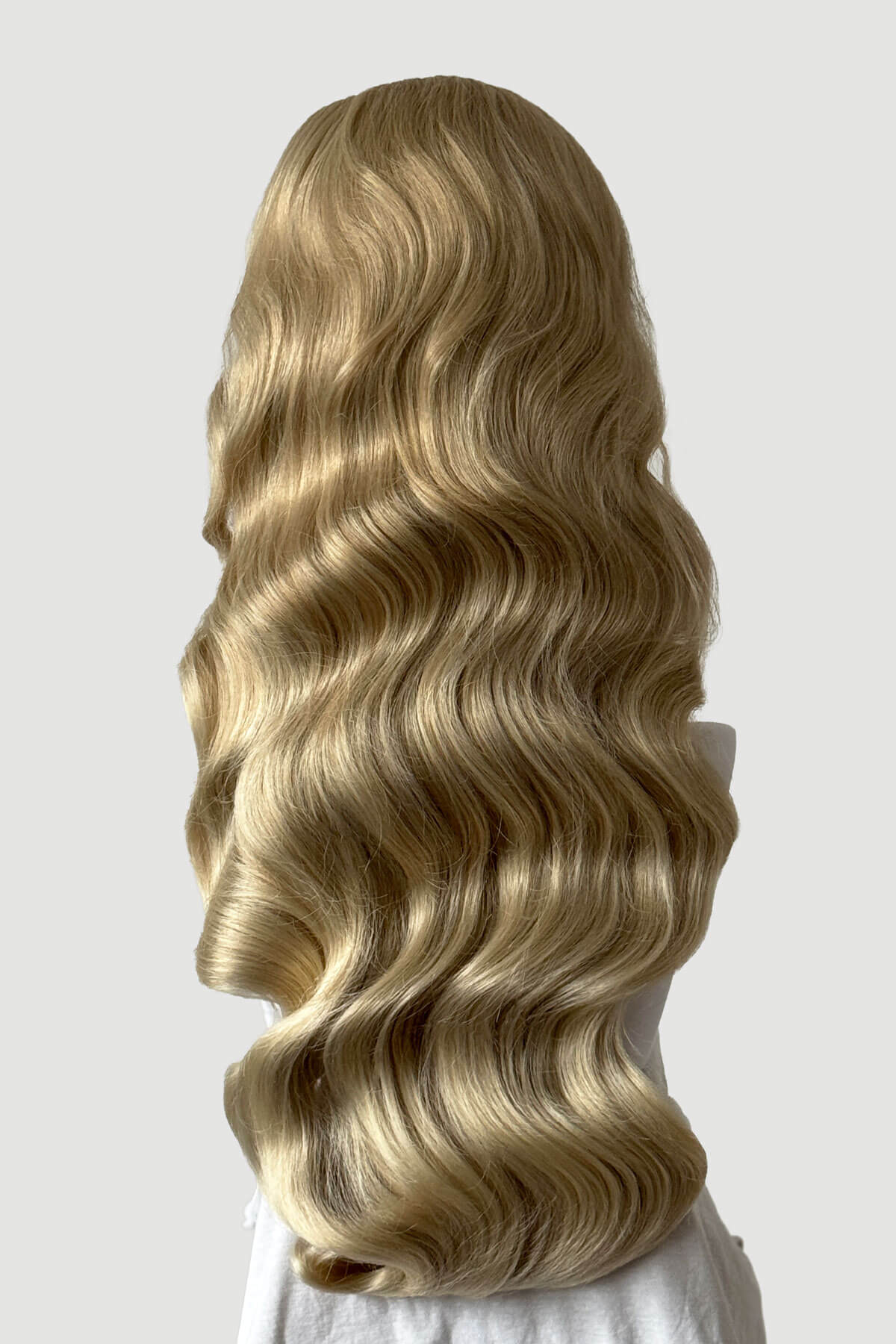 Mannequin head with long, blonde hair styled in a ponytail on a plain background. Ultra long half wig with hollywood waves. ash blonde and light blonde 613T24