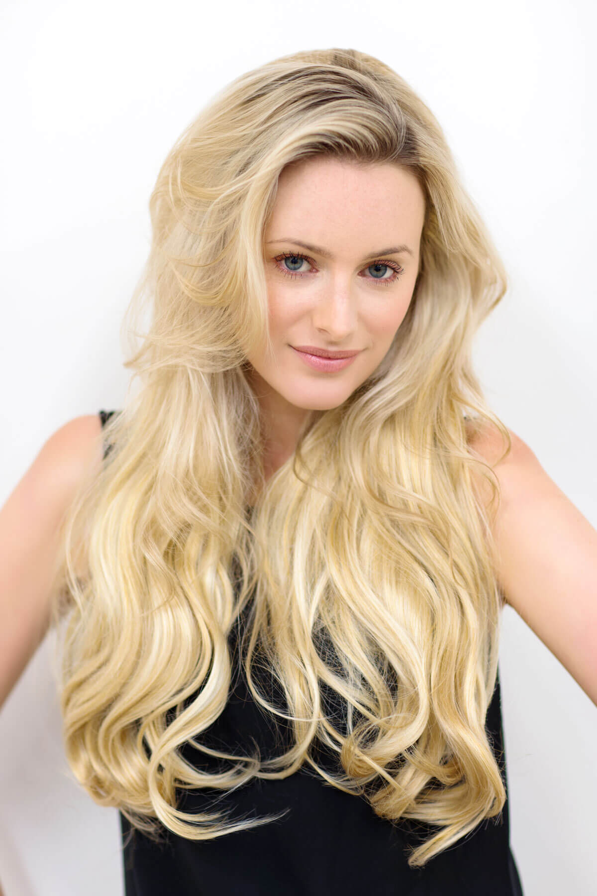Woman with long, wavy blonde hair against a white background