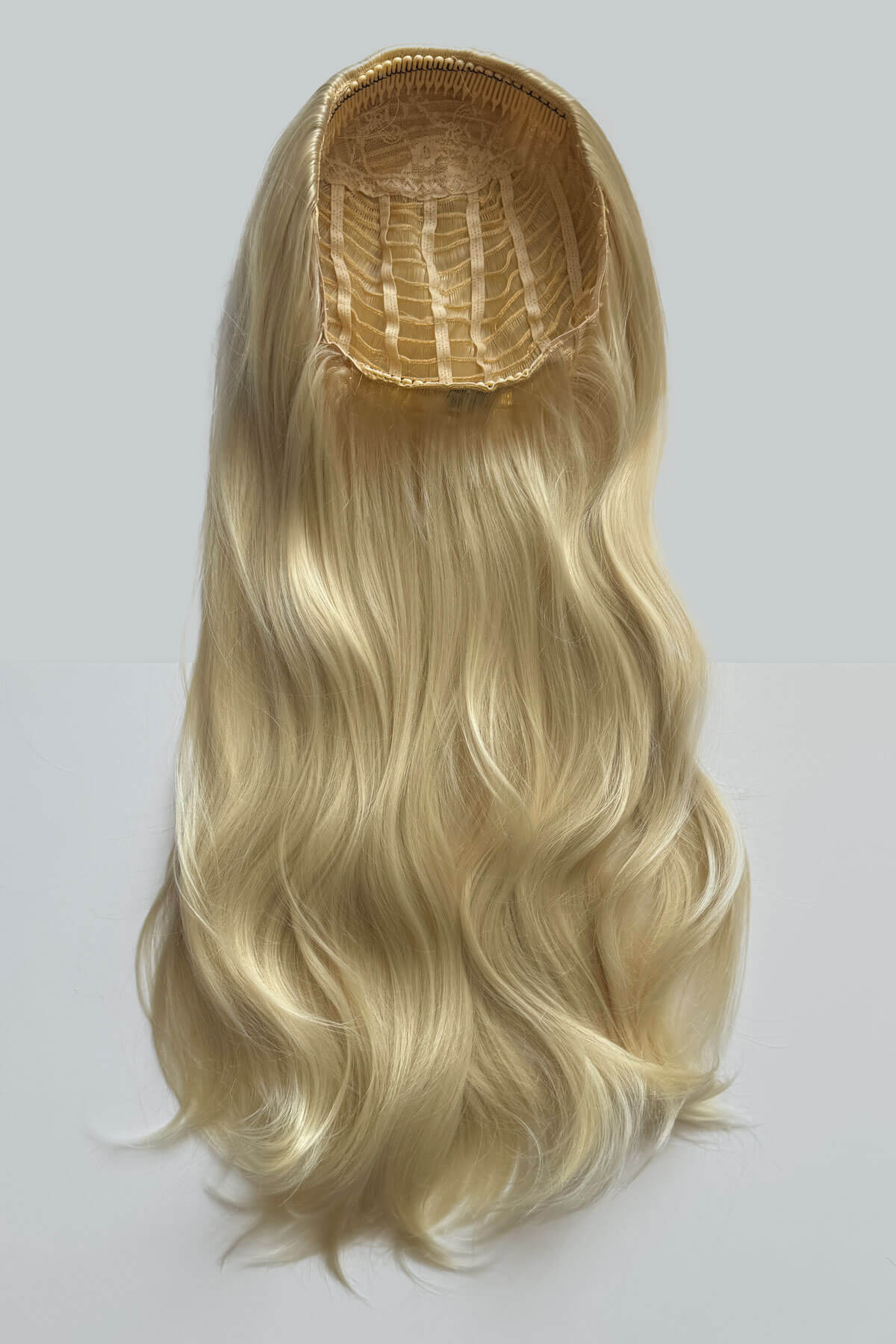Blonde hair extension on a white background. Kate - Heat Styleable Extra Long, Gentle Wave Half Wig blonde 613