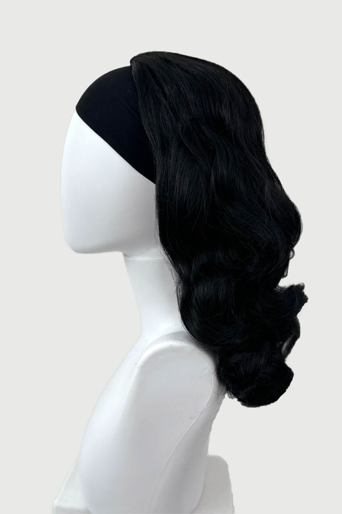 Black wig on a mannequin head against a white background. 1950s style shoulder length half wig hairpiece with beautiful vintage waves: Onyx colour jet black 1