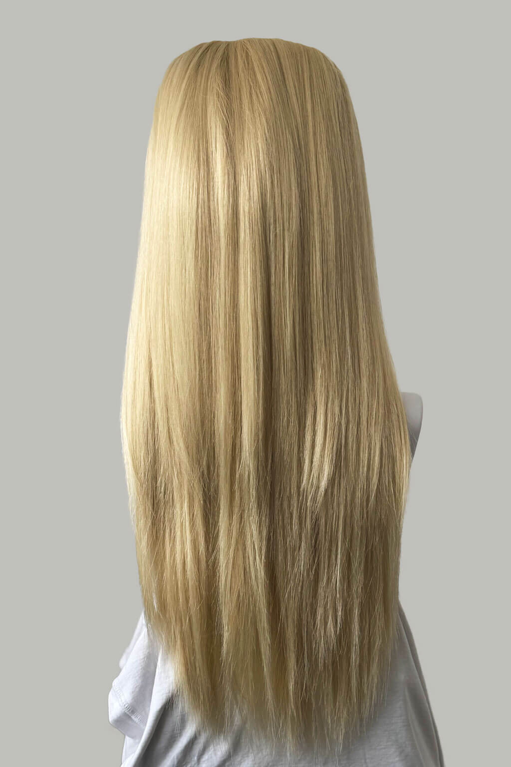 Blonde wig on a mannequin head against a gray background. 1960s style hair, high crown long straight half wig: Andrea champagne blonde 613
