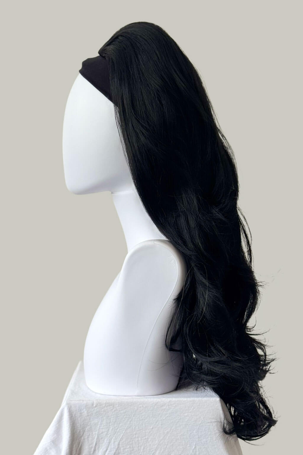 Black wig on a white mannequin head against a beige background. High crown long, layered half wig and volume ring: Helena jet black #1