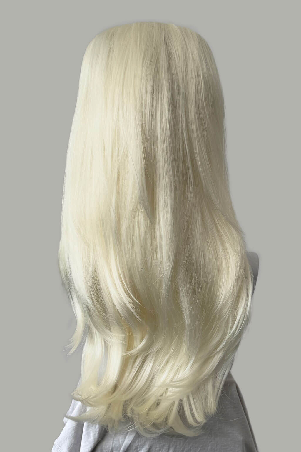 Blonde wig on a gray background. Straight platinum blonde half wig with height booster