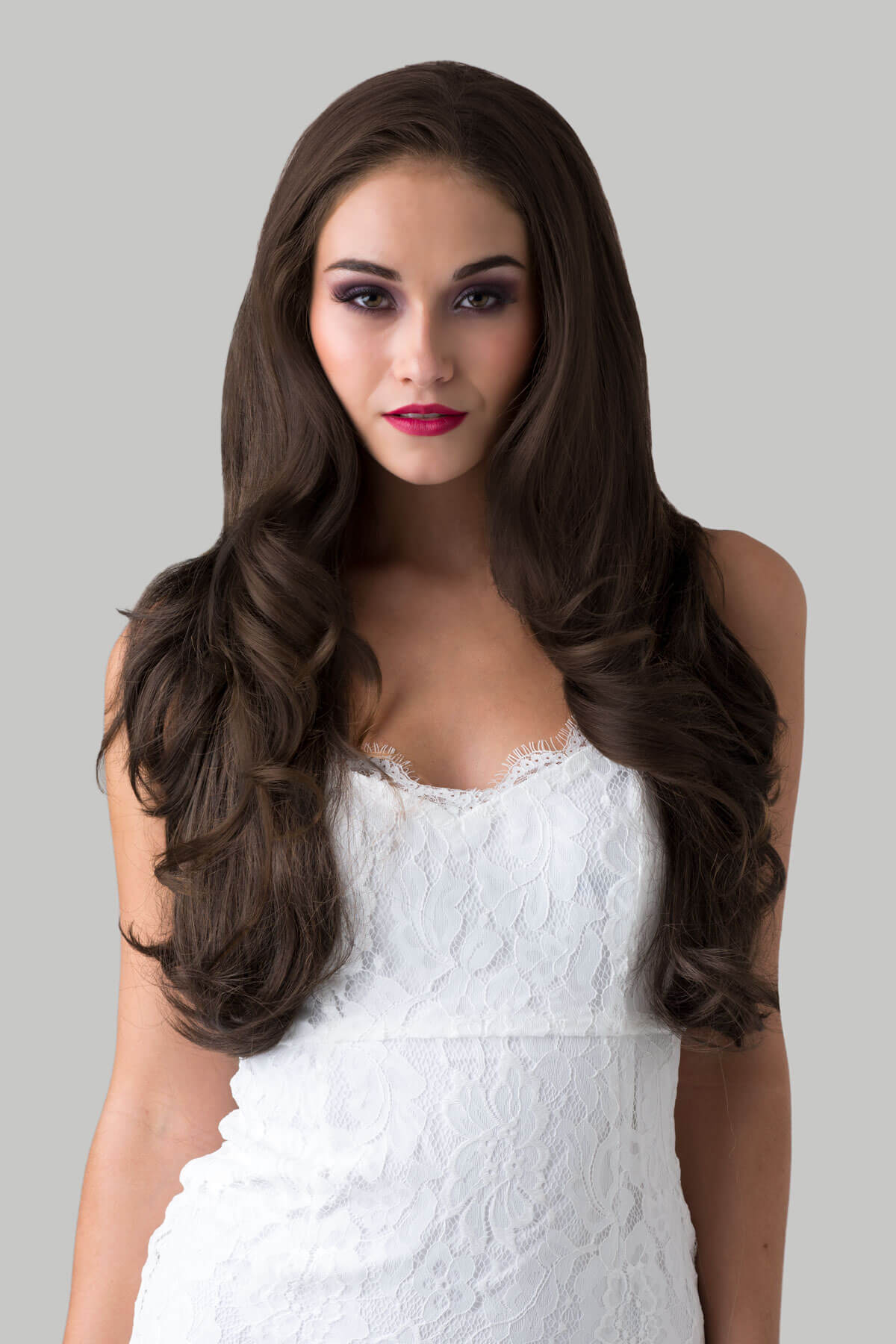 Woman with long brown hair wearing a white dress against a gray background. Brown half wig hairpiece (3/4 wig), layered, wavy: Simone chestnut brown 8