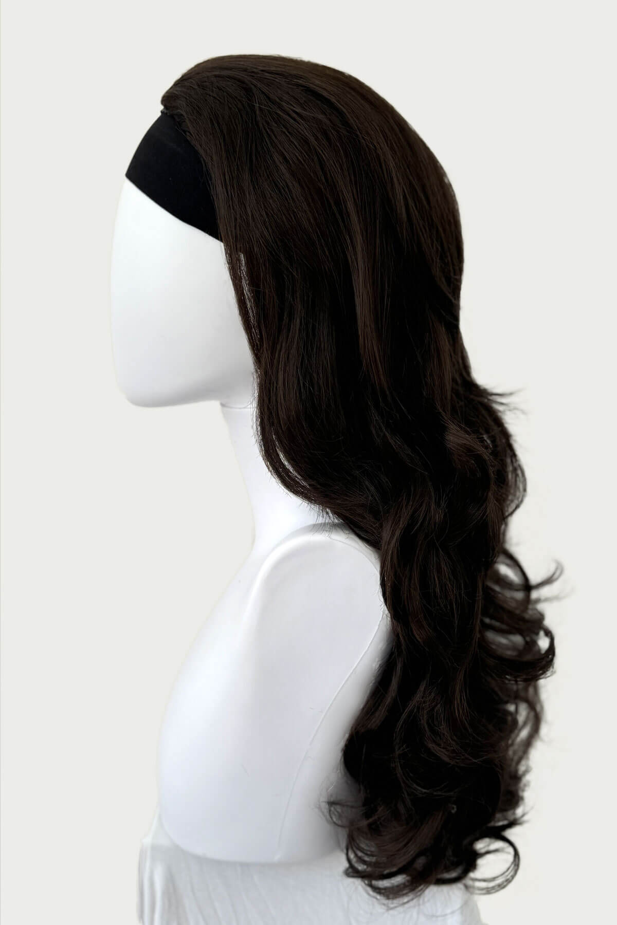 Dark brown wig on a mannequin head against a white background. Curly brown half wig hairpiece: Susan