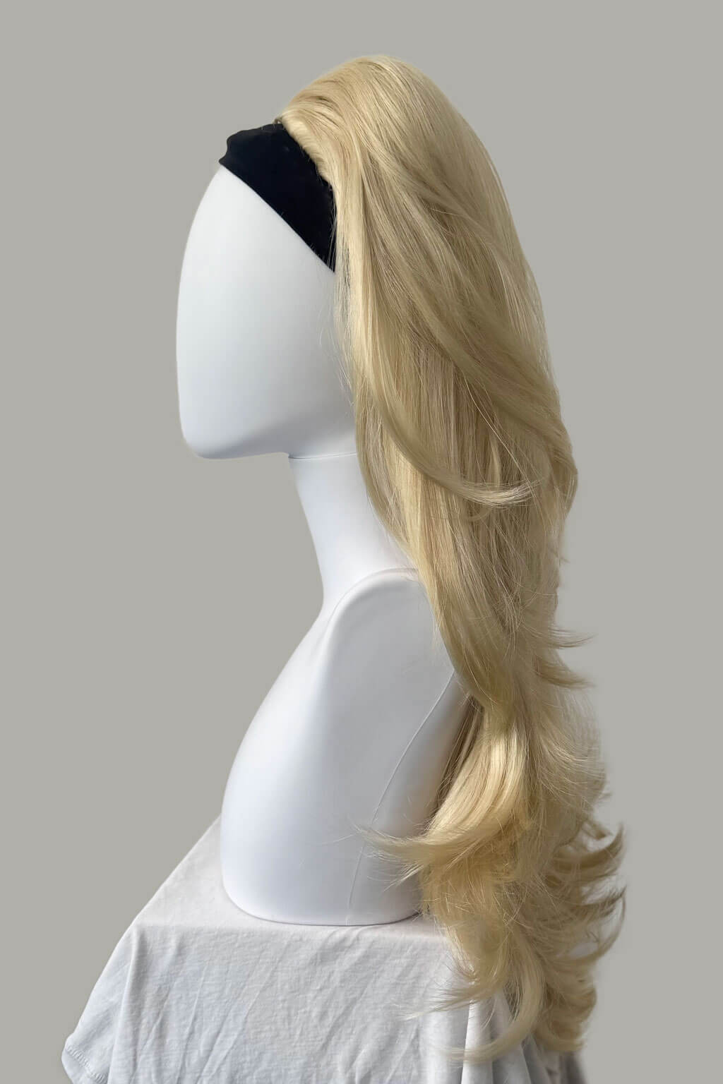 Blonde wig on a mannequin head against a plain background - High crown long, layered half wig and volume ring: Helena champagne blonde 613