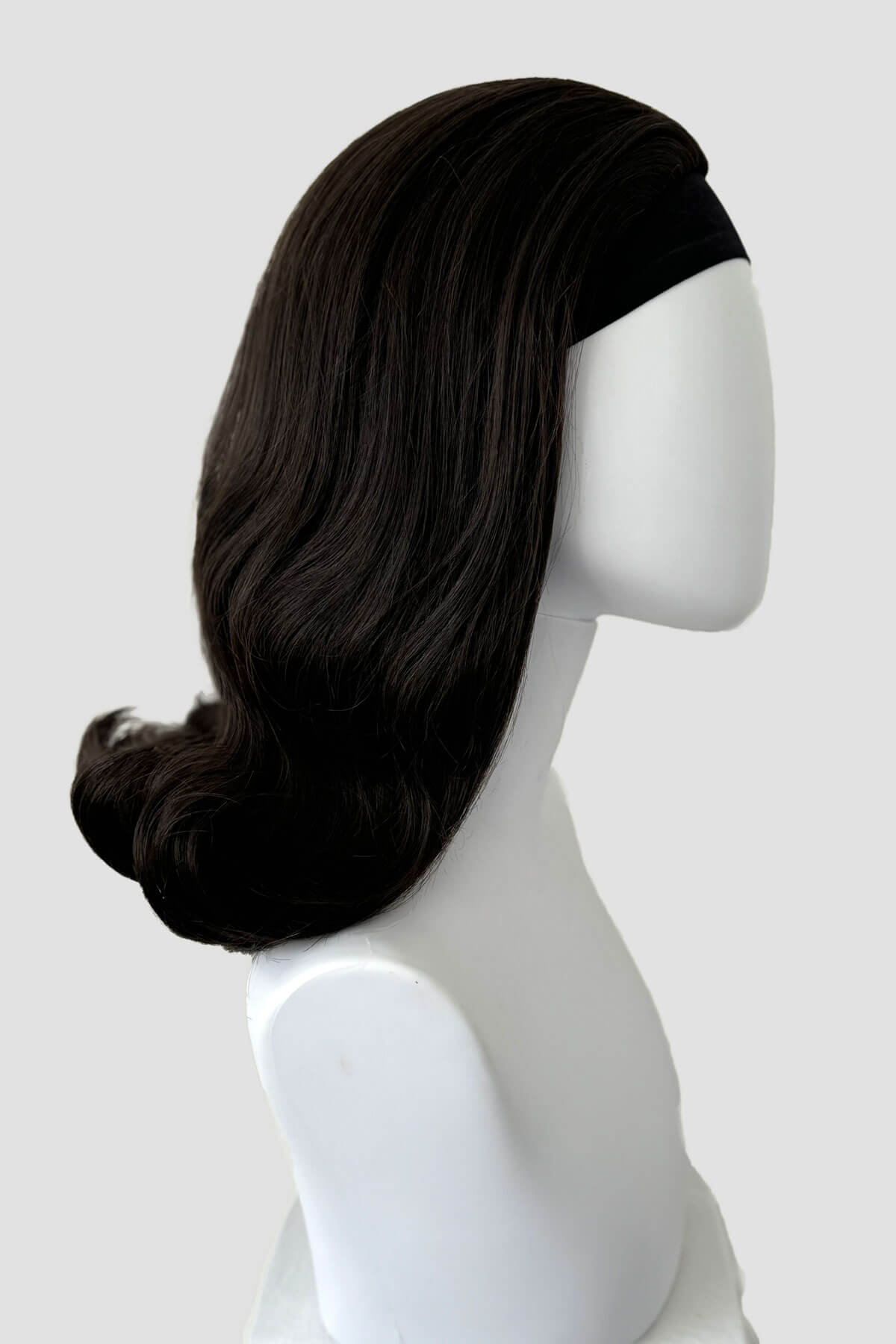 Dark brown wig on a mannequin head against a white background. 1960s half wig hairpiece, flicked, hair flip: Philippa dark brown 4