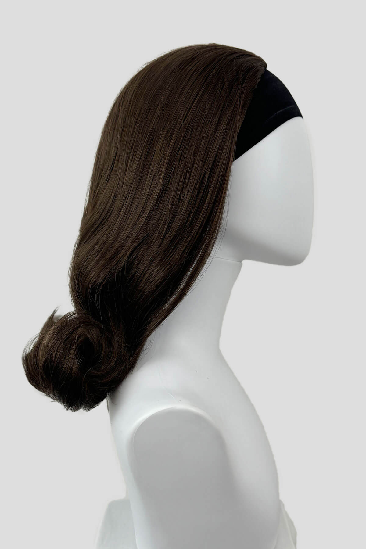 Dark brown wig on a mannequin head against a white background. 1960s half wig hairpiece, flicked, hair flip: Philippa chestnut brown 8