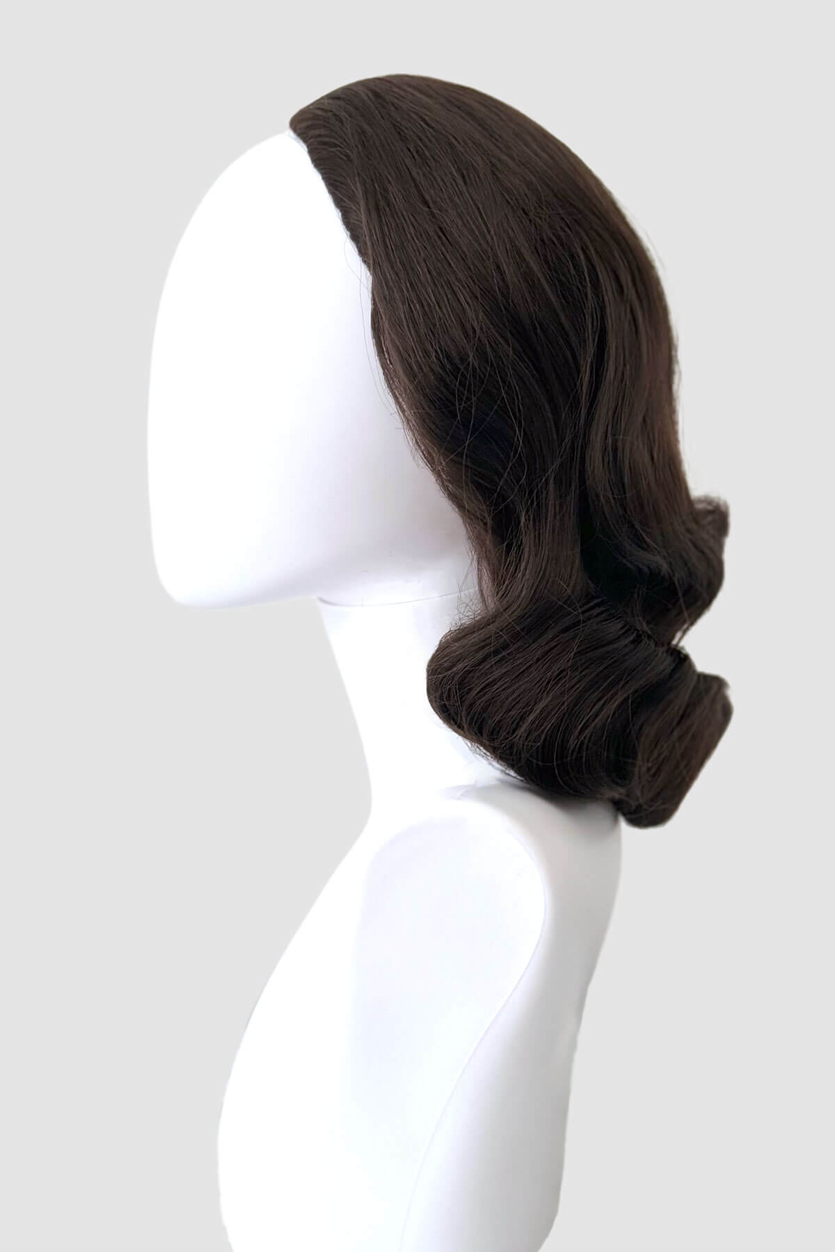 Brown wig on a white mannequin head against a light grey background. 1940s style half wig hairpiece with beautiful marcel waves: Virginia dark brown 6