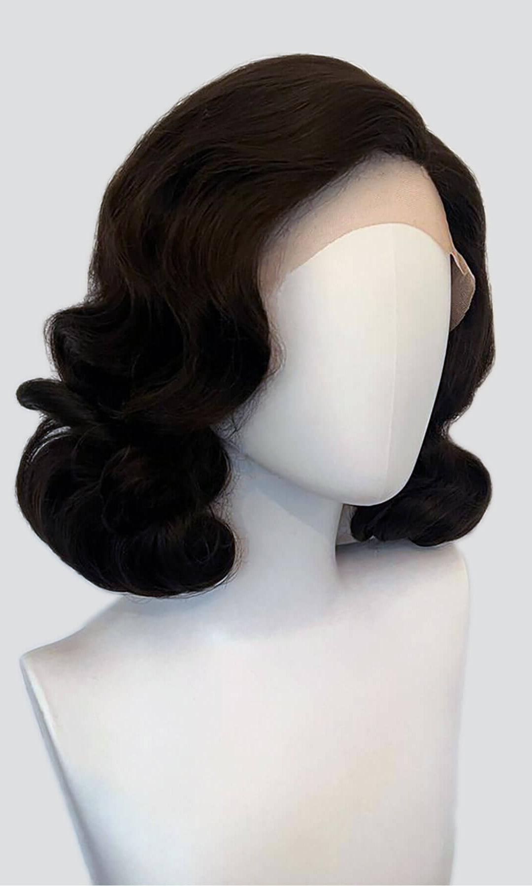 Black wig on a mannequin head against a white background. Brown lacefront wig, pinup/vintage style, mid length with finger waves: Agatha