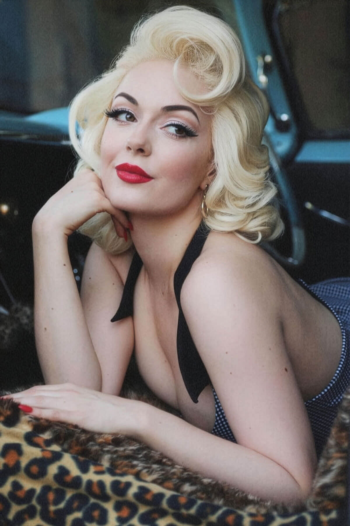 Woman with blonde hair and red lipstick posing in a vintage car interior. Blonde pinup wig, lace front, vintage style: Marilyn white blonde 1001