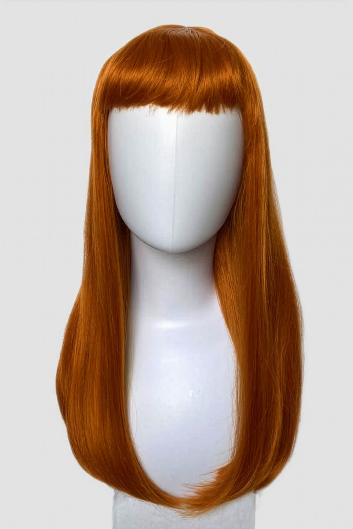 Reddish-brown wig on a white mannequin head against a white background. Long ginger wig with straight hair and a short, straight fringe: Daphne