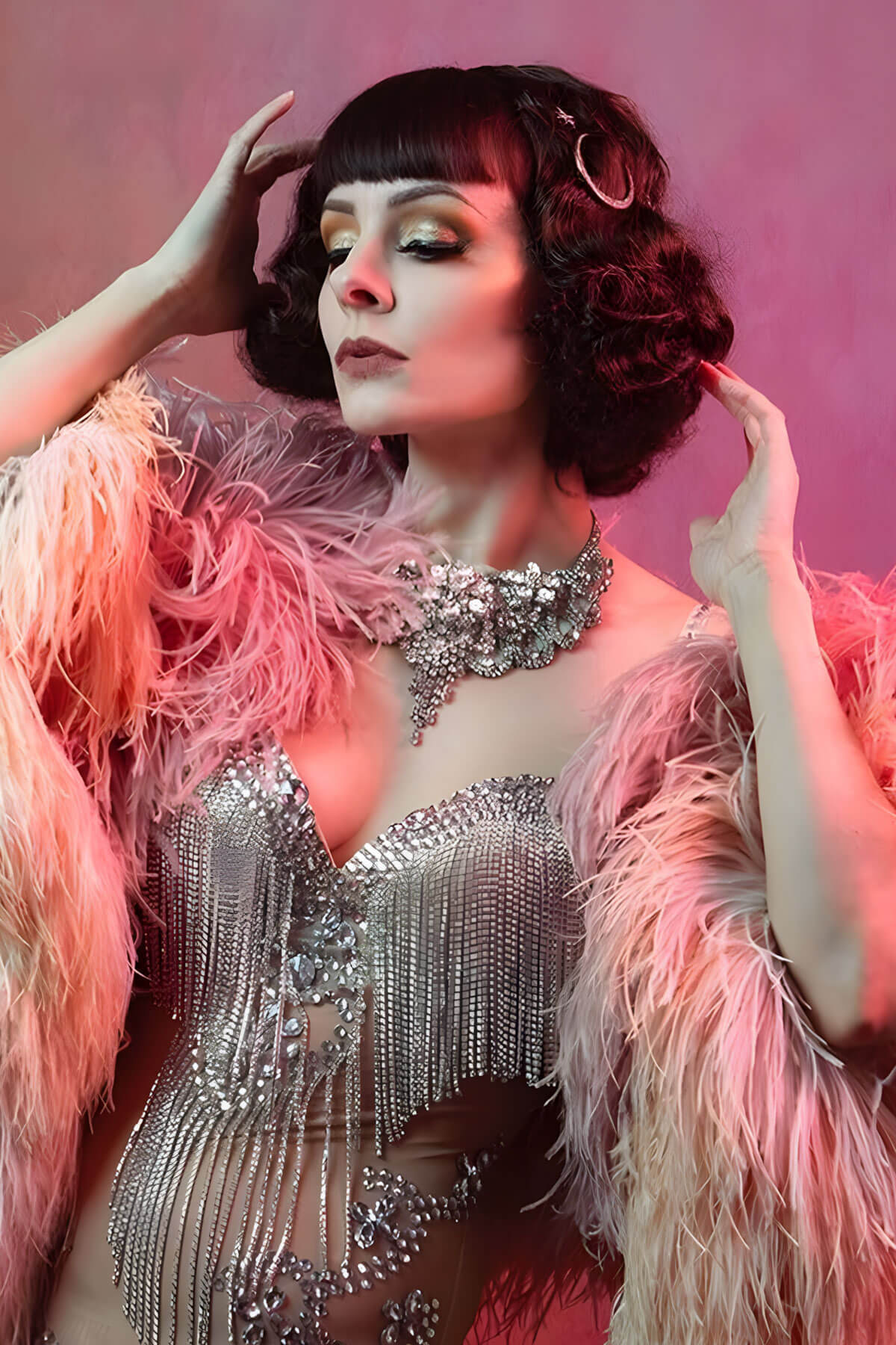 Woman in a glamorous outfit with a feathered boa against a pink background. A short brown vintage style wig with waves: Rita chestnut brown 8