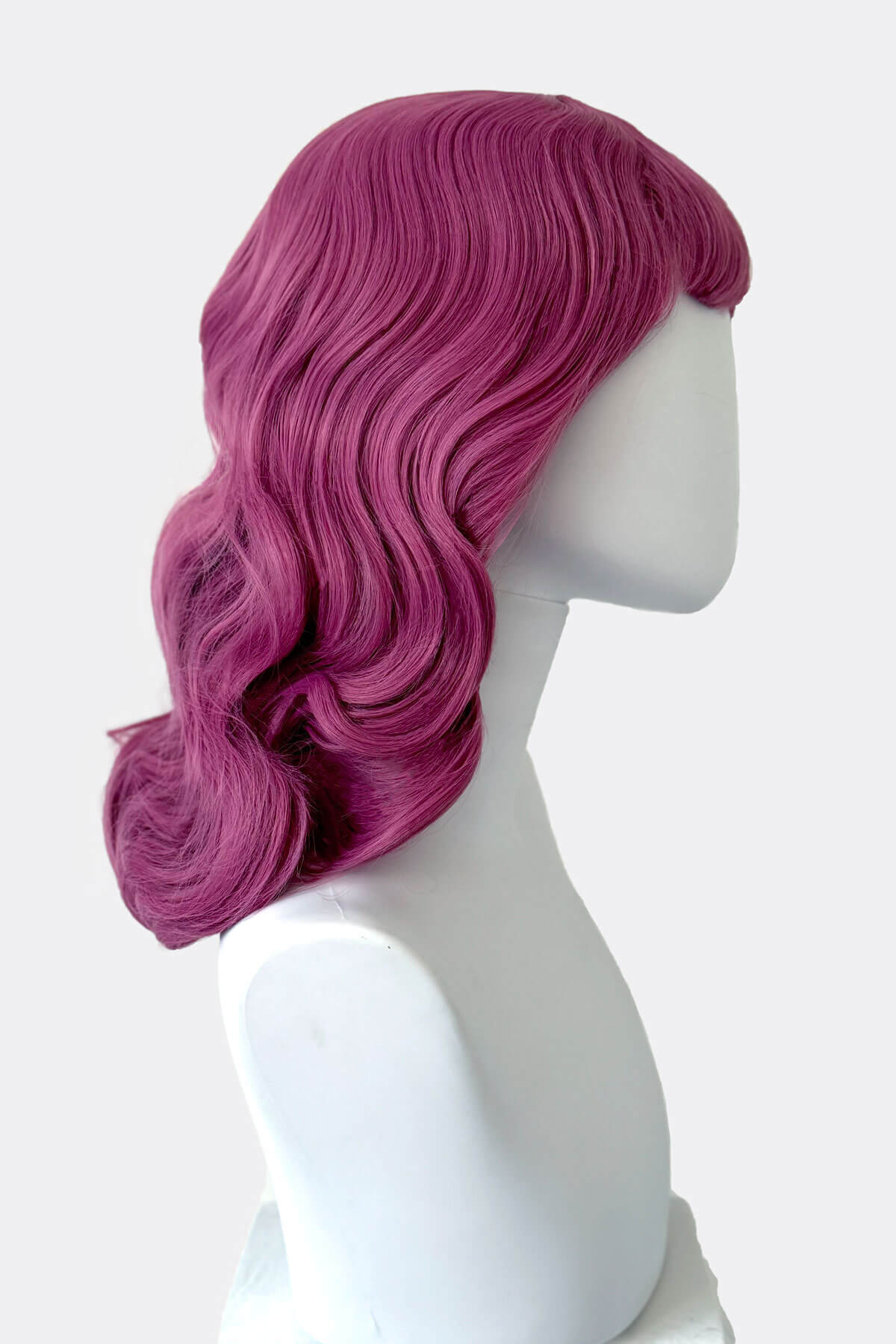 Mannequin head with vibrant pink wig on a white background. Pink pinup style wig, with finger waves and a short fringe, 1950s style: Stevie 2520J
