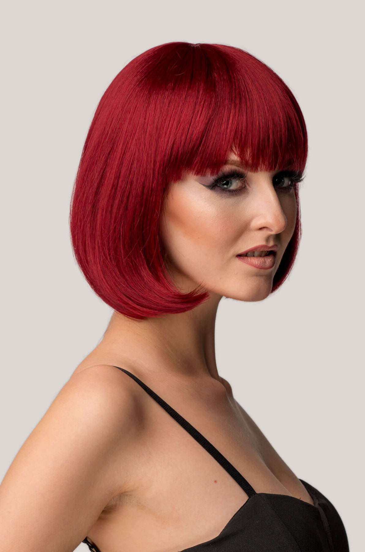 Woman with a stylish red bob haircut on a plain background
