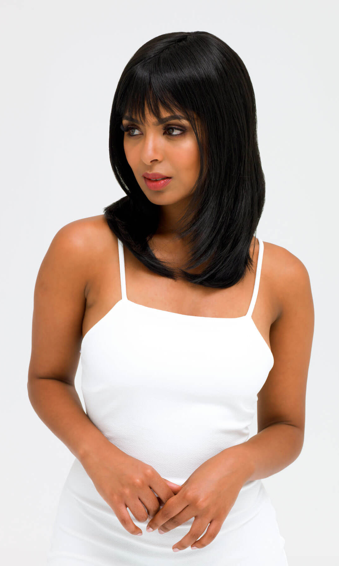 Woman with a straight black bob hairstyle wearing a white dress on a white background. Black wig straight, face frame style: Kristen