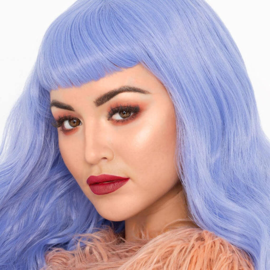 Person with blue hair and red lipstick on a white background. Long blue-purple wig with short fringe and old Hollywood waves: Ophelia