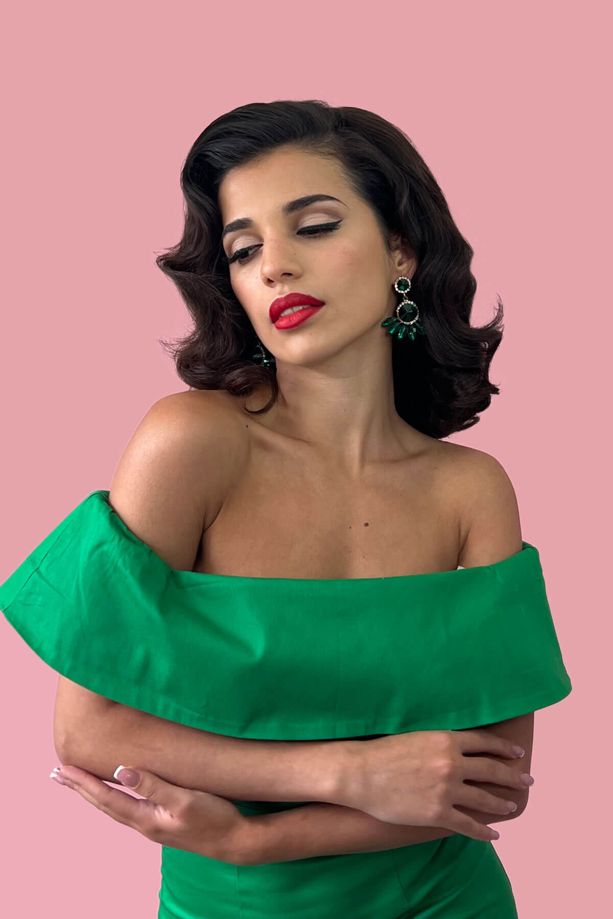 Woman with gorgeous vintage wave hair wearing a green off-shoulder dress against a pink background. 1940s style half wig hairpiece with beautiful marcel waves: Virginia jet black 1
