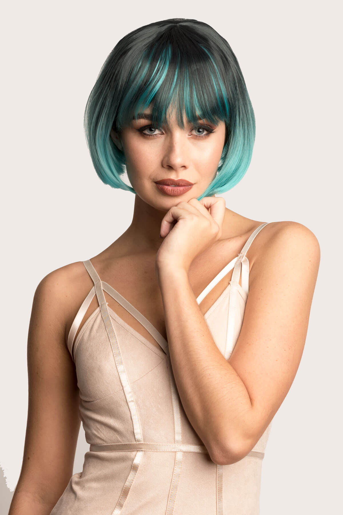 Woman with a stylish haircut and makeup on a plain background. Bob wig, black ombre blending to turquoise blue: Amara