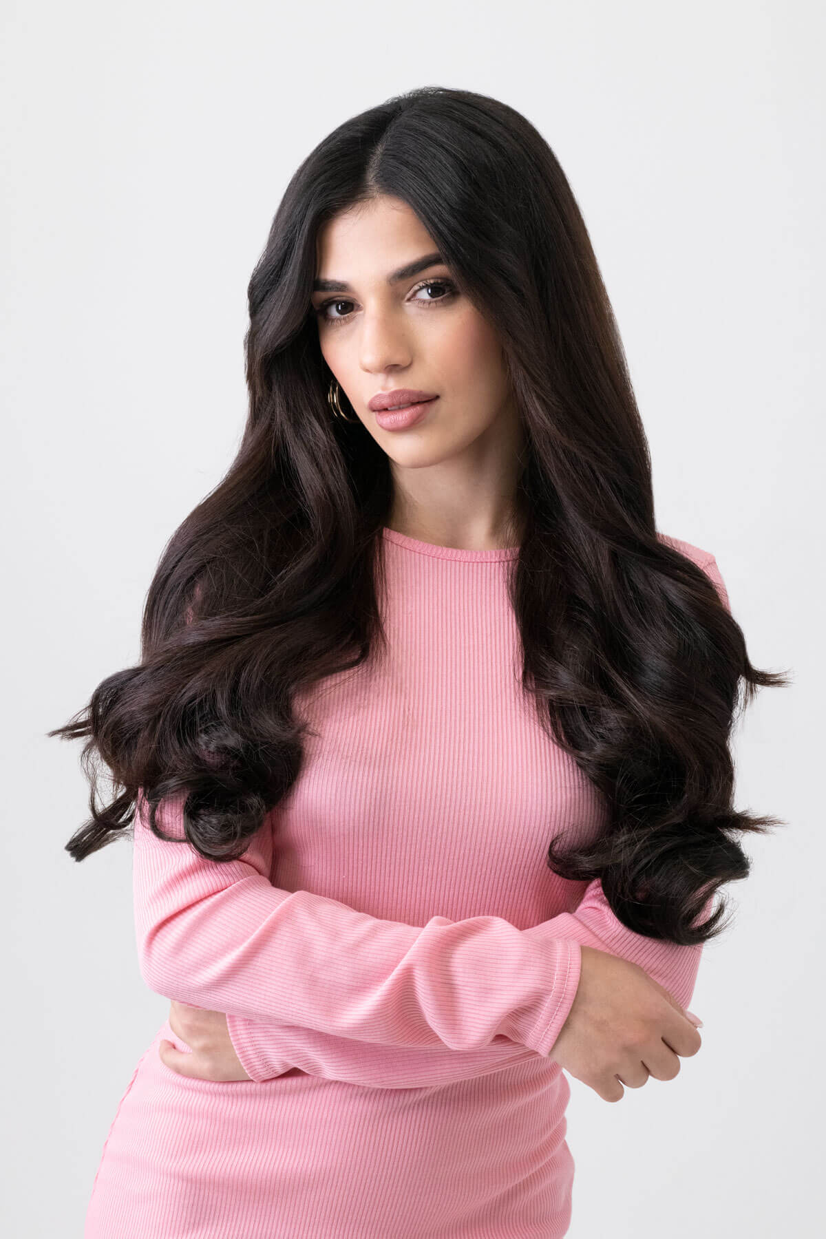 Woman wearing a pink dress against a light gray background. 1 piece, wavy, synthetic hair extension, 20", 200g