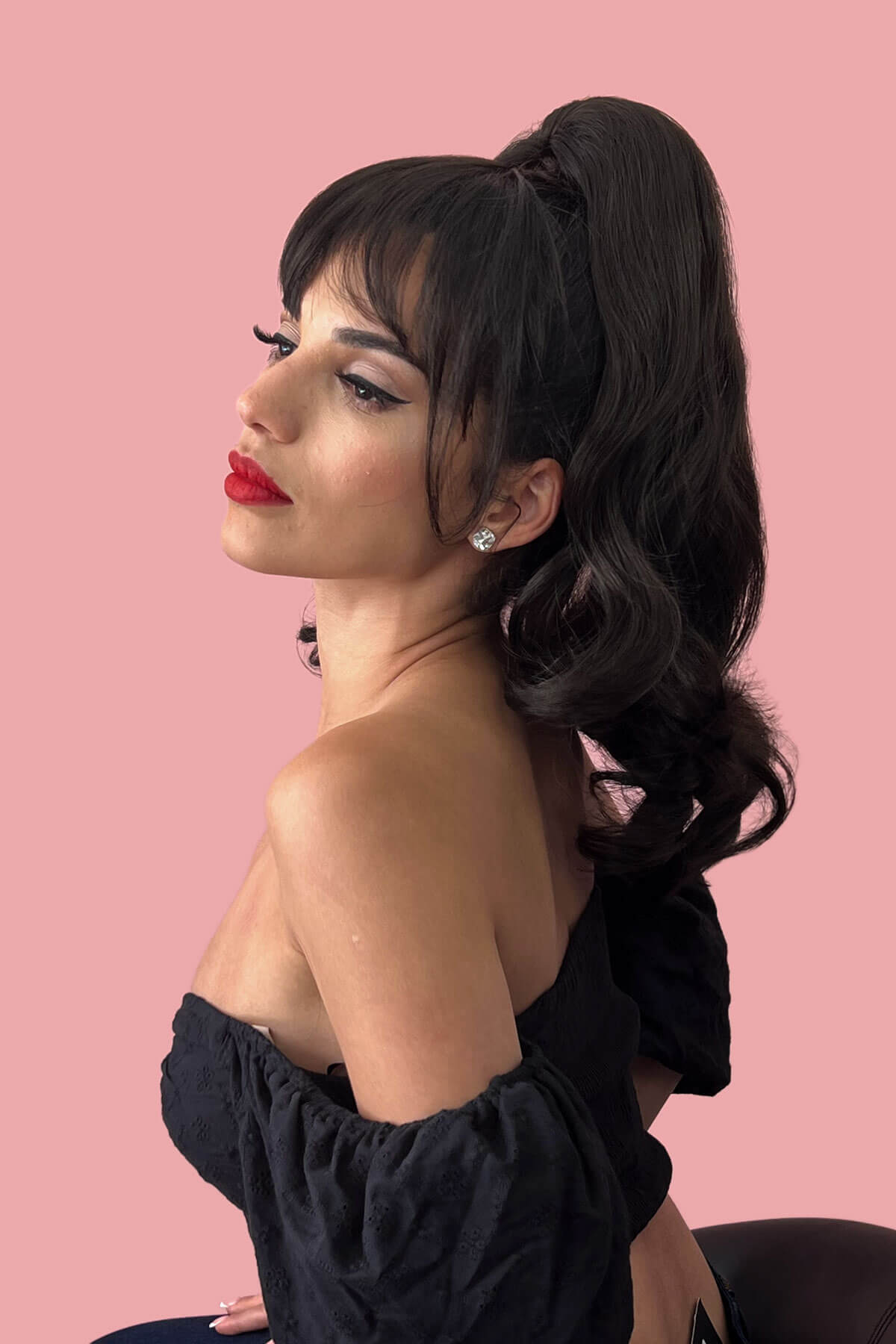 Woman with styled hair and red lipstick against a pink background. Clip in fringe hairpiece/clip-in bangs, gently feathered with face framing whisps: Delia dark brown 4