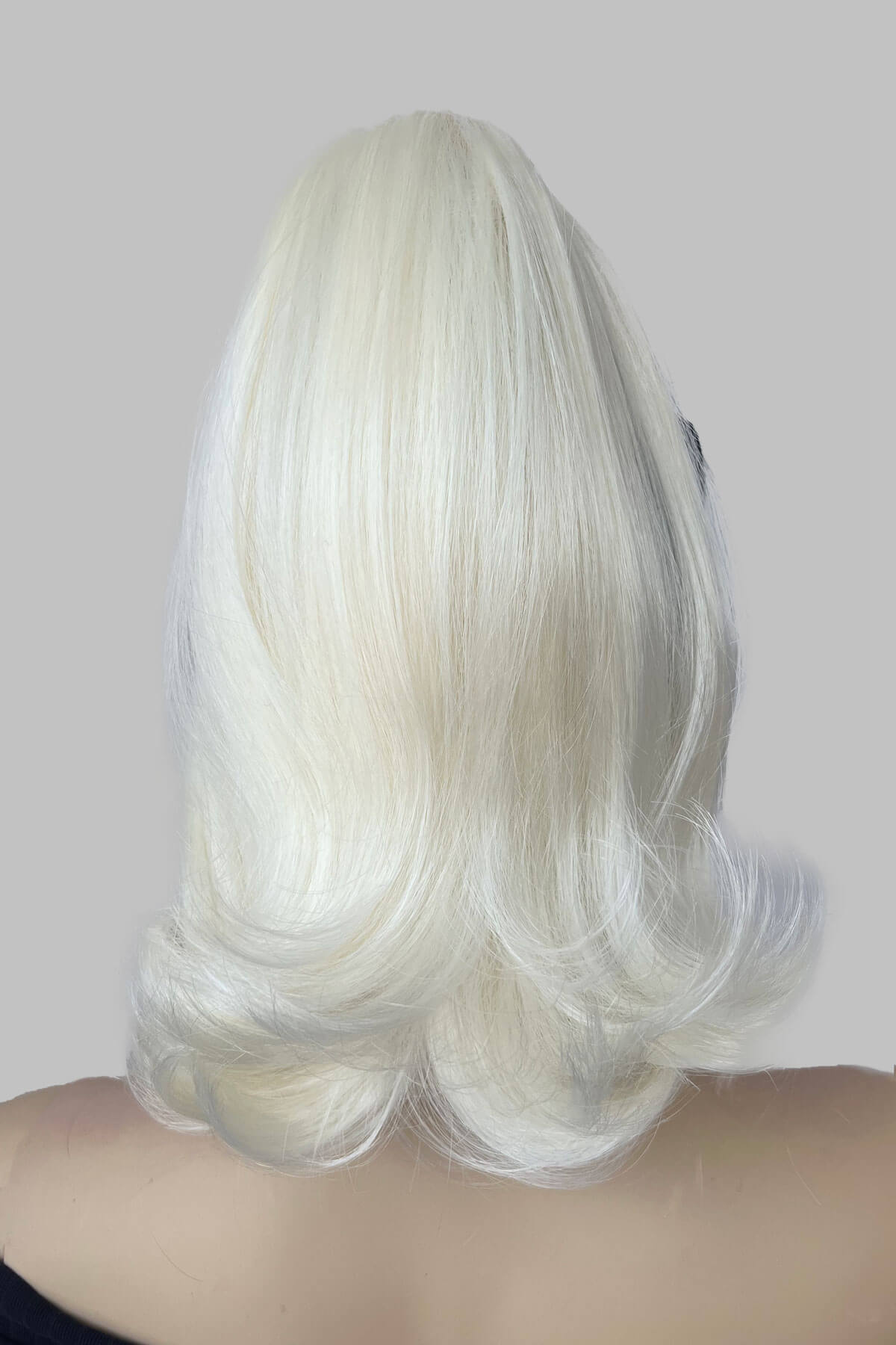 White wig on a plain background. Ponytail hairpiece, shoulder length with flick/flip, retro 1960s style: Ariana Platinum blonde 1001