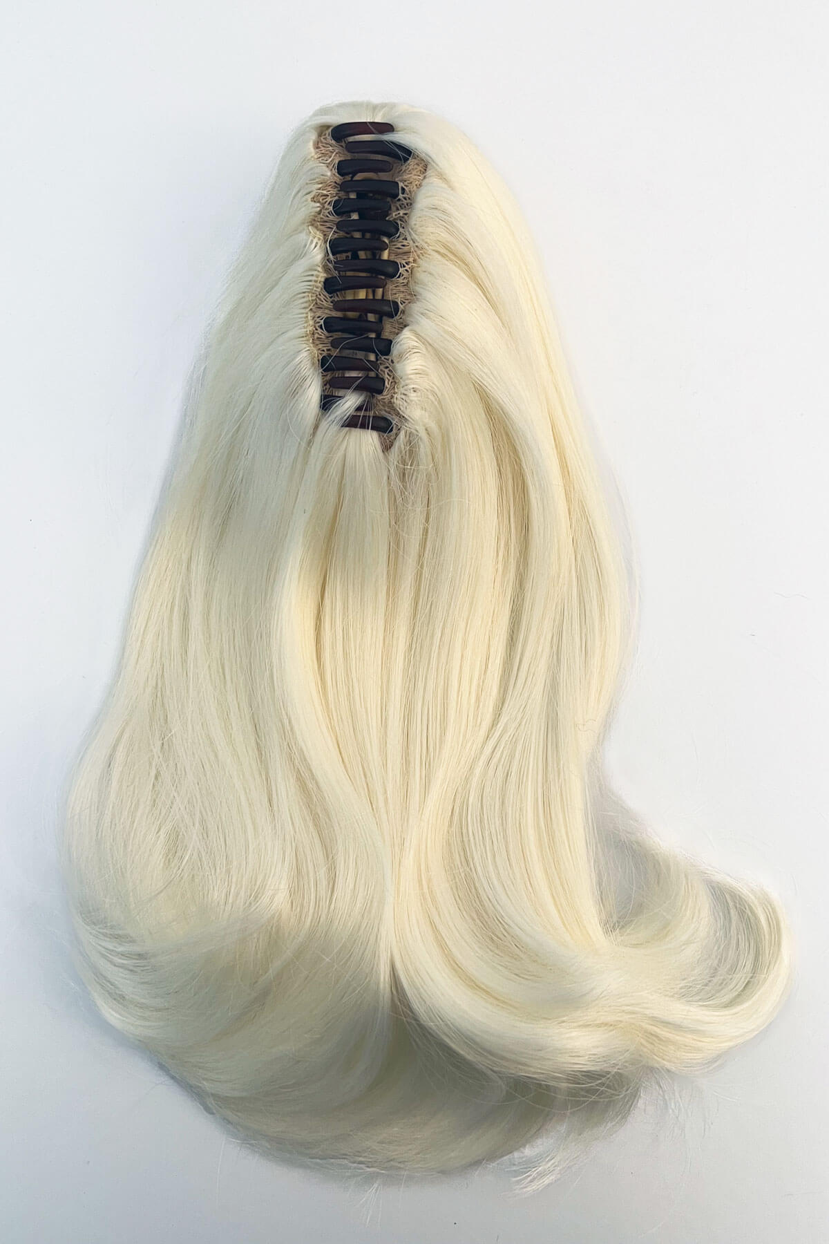 Blonde hair extension on a white background. Ponytail hairpiece, shoulder length with flick/flip, retro 1960s style: Ariana Platinum blonde 1001