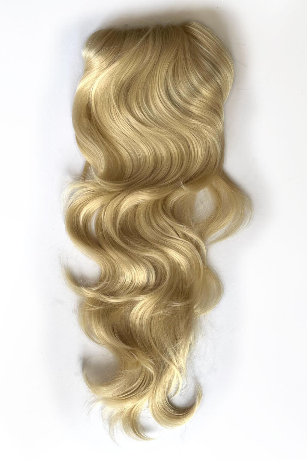 A long, wavy blonde hair extension or wig piece with soft golden highlights and lowlights, shown against a plain white background. Double volume hairpiece extension: Naomi blonde 613