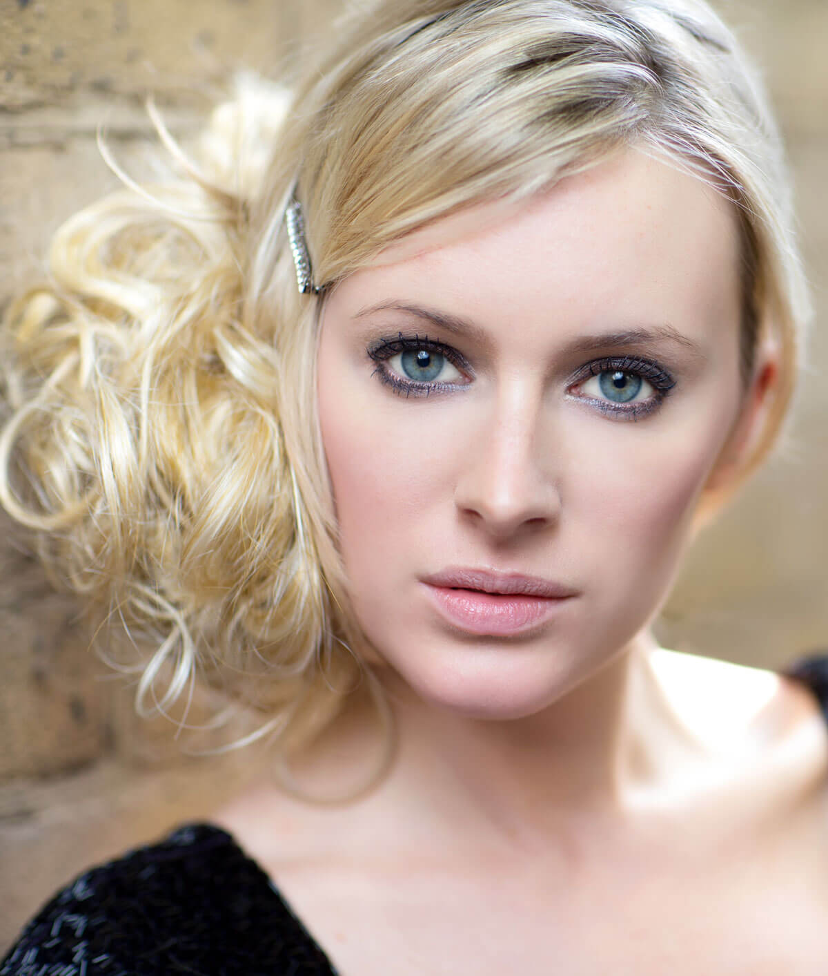 Woman with styled blonde hair against a neutral background.  Extension hairpiece, long, versatile, Flexihair: Cristina wheatfield blonde 24H613