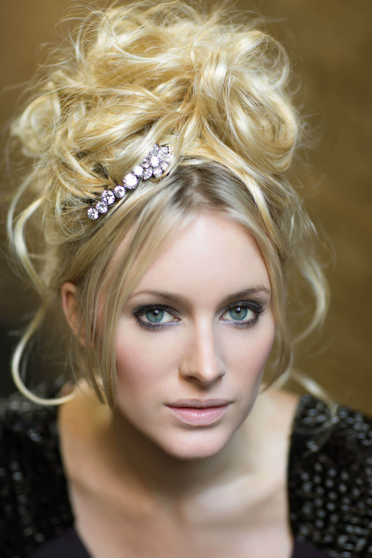 Woman with blonde hair styled in an updo with a decorative headband against a neutral background.  Extension hairpiece, long, versatile, Flexihair: Cristina wheatfield blonde 24H613
