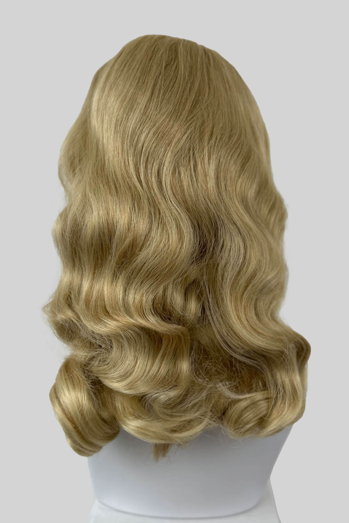 Blonde wig on a mannequin head against a white background. 1950s style half wig hairpiece with beautiful waves: Morgana blonde 613T24